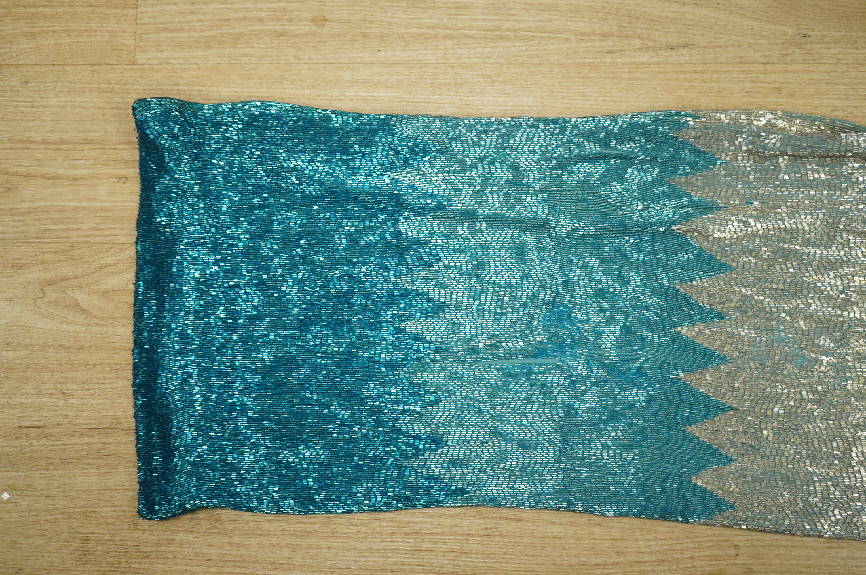 A graduated beaded turquoise and silver bugle beaded evening dress, with large turquoise metalic bows at the shoulders with diamonte, pearl and bead tassel decoration, bust front 39cm, length 127cm